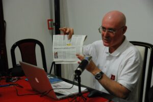 Roberto Giurastante mostra alla platea una copia del giornale locale che riprende la dicitura "eversivo e pericoloso per la pace" per descrivere il ricorso al TAR presentato da Trieste Libera.